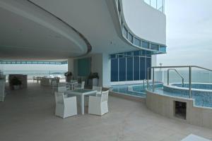 een gebouw met een zwembad en een tafel en stoelen bij 14H - Luxury Resort Panama with Rooftop Pool in ArraijÃ¡n