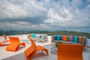 een patio met stoelen en banken op een dak bij 14H - Luxury Resort Panama with Rooftop Pool in ArraijÃ¡n