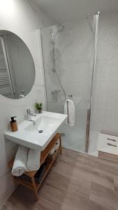 Habitación con baño privado Bilbao في بلباو: حمام مع حوض أبيض ودش