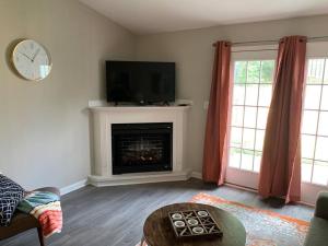 a living room with a fireplace with a flat screen tv at Comfy, Stylish Townhome Near I-20! in Augusta