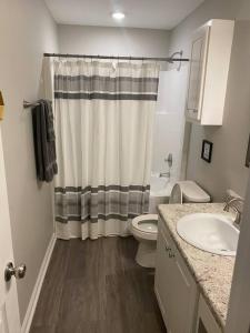 a bathroom with a toilet and a shower curtain at Comfy, Stylish Townhome Near I-20! in Augusta