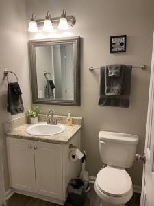 a bathroom with a toilet and a sink and a mirror at Comfy, Stylish Townhome Near I-20! in Augusta