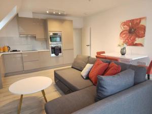 a living room with a couch and a table and a kitchen at Paradigm Court, Brand New 1-Bedroom Flat (5), Oxford in Oxford