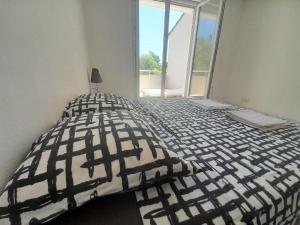 a bedroom with a black and white bed with a window at T2 duplex + piscine avec parking in Montpellier +2 photos