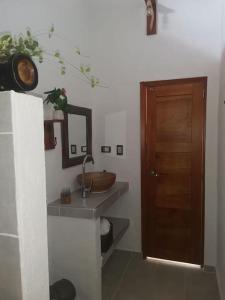 a bathroom with a sink and a wooden door at CasaBongo, alojamiento vacacional con piscina in Honda