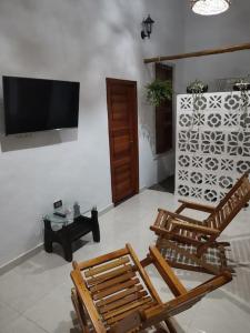 a living room with two chairs and a flat screen tv at CasaBongo, alojamiento vacacional con piscina in Honda