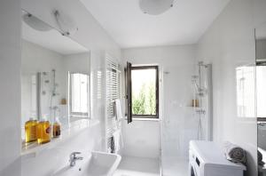 a white bathroom with a sink and a shower at Sopot BC 1957 Apartments in Sopot