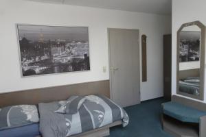 ein Schlafzimmer mit einem Bett und einem Bild einer Stadt in der Unterkunft Pension Egerer in Bad Köstritz