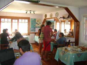 a group of people sitting at tables in a restaurant at Hosteria Cumelen in San Martín de los Andes