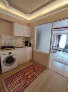 a kitchen with a stove and a washing machine at Cozy 1+1 and garden, in center of İstanbul in Istanbul