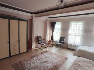 a bedroom with two chairs and a bed and a window at Cozy 1+1 and garden, in center of İstanbul in Istanbul