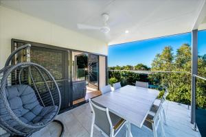 a dining room with a table and chairs on a balcony at 3 Bedroom Holiday Home Valley Views in Airlie Beach in Airlie Beach