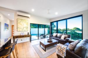 a living room with a couch and a table at 3 Bedroom Holiday Home Valley Views in Airlie Beach in Airlie Beach