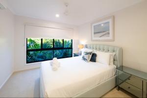 a bedroom with a large white bed and a window at 3 Bedroom Holiday Home Valley Views in Airlie Beach in Airlie Beach +14 photos
