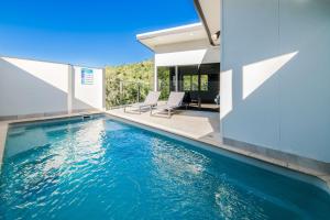 a swimming pool in the middle of a house at 3 Bedroom Holiday Home Valley Views in Airlie Beach in Airlie Beach