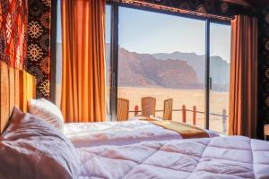 a bedroom with a bed and a view of the desert at Magic Bedouin Star in Wadi Rum