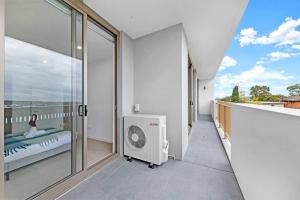 a white room with a balcony with a fan at Entire Apartment in Ryde in Sydney