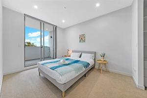 a bedroom with a bed and a large window at Entire Apartment in Ryde in Sydney