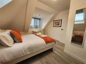 sypialnia z łóżkiem z pomarańczowymi i białymi poduszkami w obiekcie Paradigm Court, Modern 1-Bedroom Apartment, Oxford w Oksfordzie