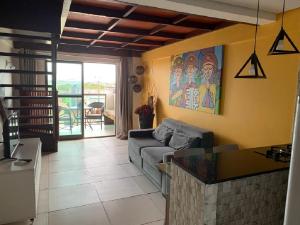 a living room with a couch and a table at Flat 402 Laguna Beach - tipo Loft encantador, mobiliado e aconchegante in Porto De Galinhas
