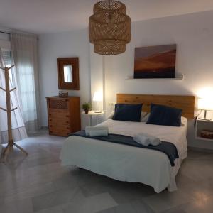 1 dormitorio con 1 cama grande con almohadas azules en "La Casita de Sal" cerca de la playa, con piscina comunitaria y wifi, en La Herradura