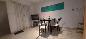a dining room with a table and chairs and a television at Alquiler cintia 2 in Gualeguaychú