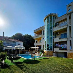 a large apartment building with a swimming pool and umbrellas at Kopernikus Apartments in Ulcinj
