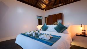 1 dormitorio con 1 cama con toallas en Bebeladan Beach Resort, In The Last Indigenous Corner, en El Nido
