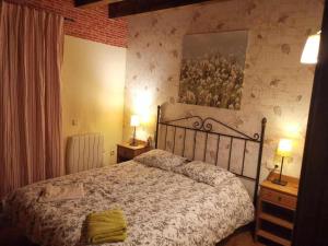 1 dormitorio con 1 cama, 2 mesitas de noche y 2 lámparas en Casa de piedra y madera vistas al Cadí en Bellver de Cerdanya 