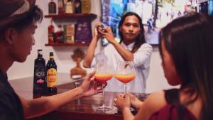 un grupo de personas sentadas en un bar con copas de vino en Bebeladan Beach Resort, In The Last Indigenous Corner en El Nido