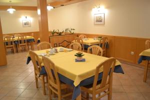a restaurant with tables and chairs with yellow table cloth at Mini Hotel in Škofja Loka