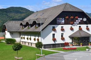 a white building with a black roof at Mini Hotel in Škofja Loka