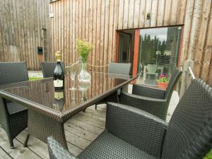 a glass table with chairs and a bottle of wine at Spacious chalet in residential area, modern, luxury interior, large terrace in Harrachov