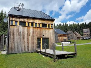a wooden barn with a bench in front of it at Spacious chalet in residential area, modern, luxury interior, large terrace in Harrachov