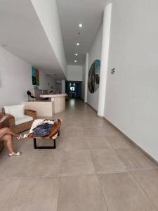 uma pessoa sentada num sofá numa sala de estar em Espectacular apartamento Santa Marta em Santa Marta