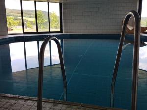 una piscina con dos barras de metal en un edificio en Chalet in Gerolstein near Forest Trails, en Hinterhausen