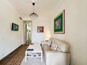 a living room with a couch and a table at Belvilla by OYO Rambla Paris Apartment in Barcelona