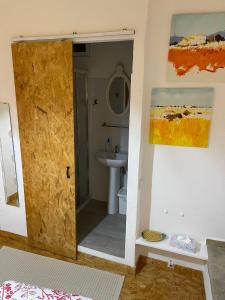 un baño con una puerta que conduce a un lavabo en Casarão AL en Olhão