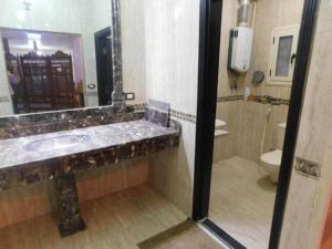 La salle de bains est pourvue d'un lavabo, de toilettes et d'un miroir. dans l'établissement فيلا للايجار مفروش بمدينة العبور, à ‘Ezbet el-Insha