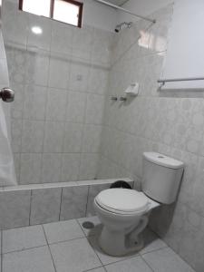 uma casa de banho branca com um WC e um chuveiro em Kuelap Guest House em Chachapoyas