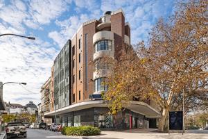 a tall brick building on the corner of a street at Orange Stay Apartments Potts Point in Sydney