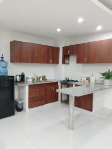 eine Küche mit Holzschränken und einer Marmoroberfläche in der Unterkunft Departamento Altos del Sur in Santa Cruz de la Sierra