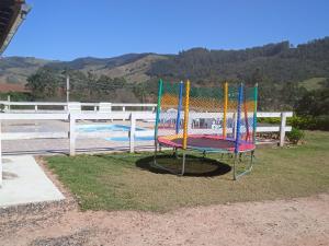 een kleurrijke trampoline naast een zwembad bij Chácara do vô Meireles in Serra Negra