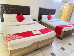 2 camas con almohadas rojas en una habitación en Hotel Star Palace - Near Karol Bagh Metro, en Nueva Delhi