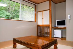 sala de estar con mesa de centro frente a una ventana en Hana No Paradise en Nasu