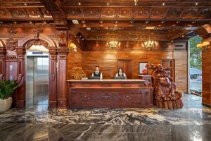 a lobby with two people sitting at a reception desk at Monalisa Luxury Hotel in Danang