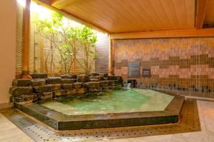 a pool of water in a building with chairs in it at Ooedo Onsen Monogatari Premium Kinosaki in Toyooka