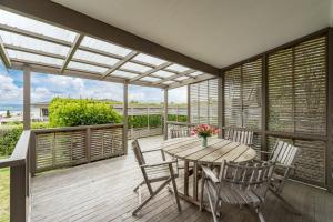 un patio con una mesa de madera y sillas en una terraza en Greenhaven with wi-fi, en Taupo