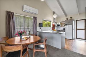 a kitchen and dining room with a wooden table and chairs at Greenhaven with wi-fi in Taupo +12 photos