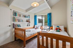 a bedroom with two beds and a book shelf at Greenhaven with wi-fi in Taupo